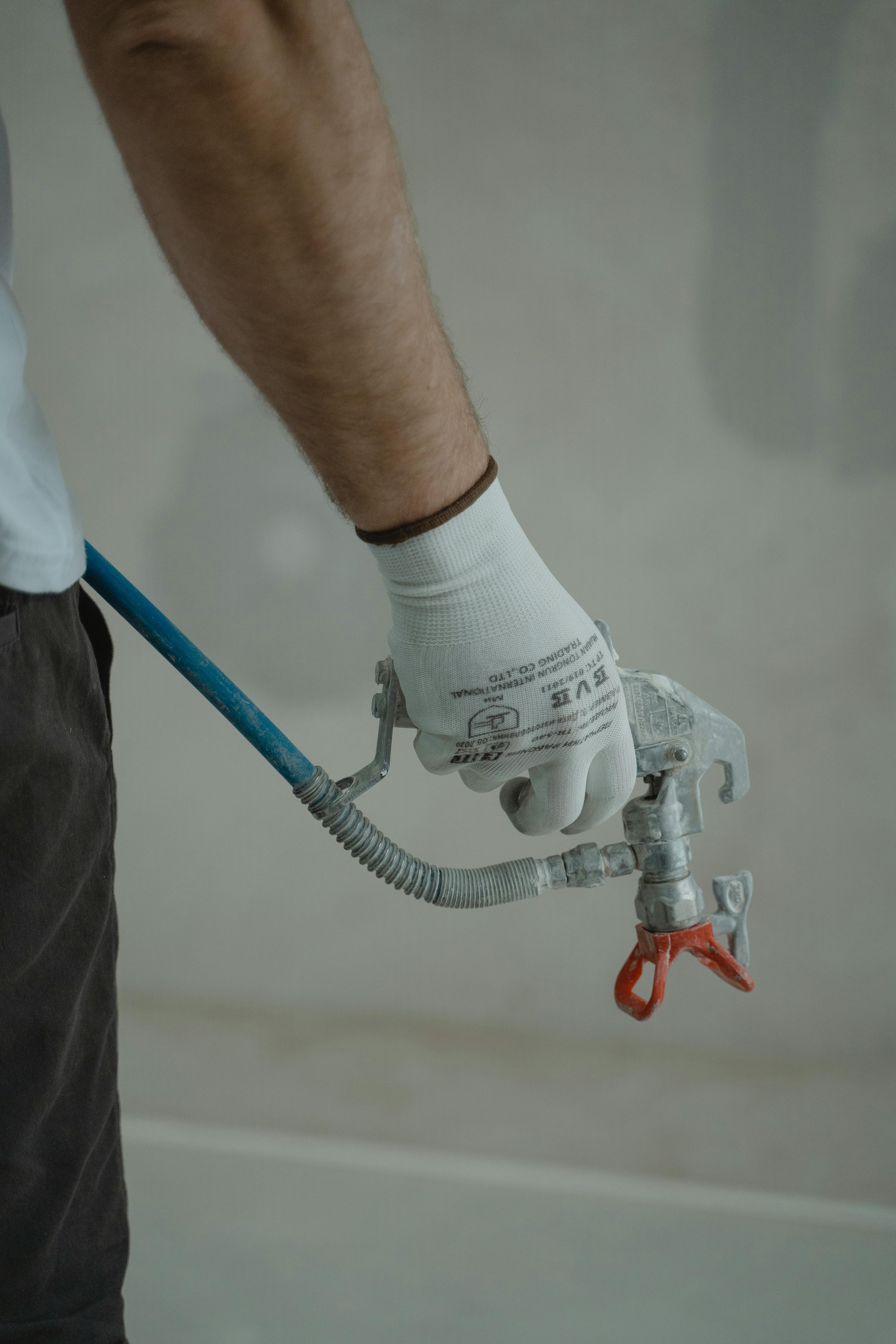 Licensed plumber working under a kitchen sink